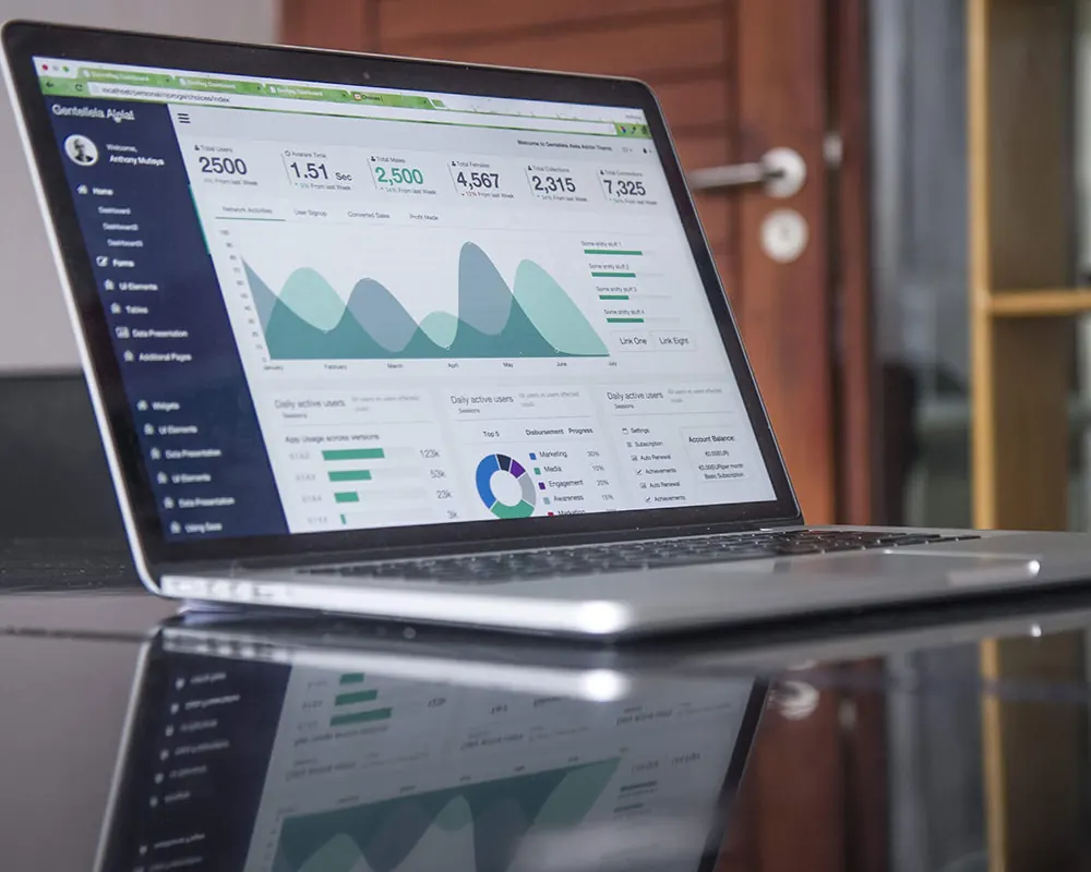 A laptop showing a website dashboard with traffic and activity charts