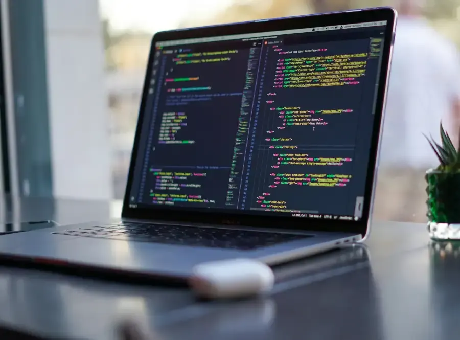 Laptop on a desk showing website code